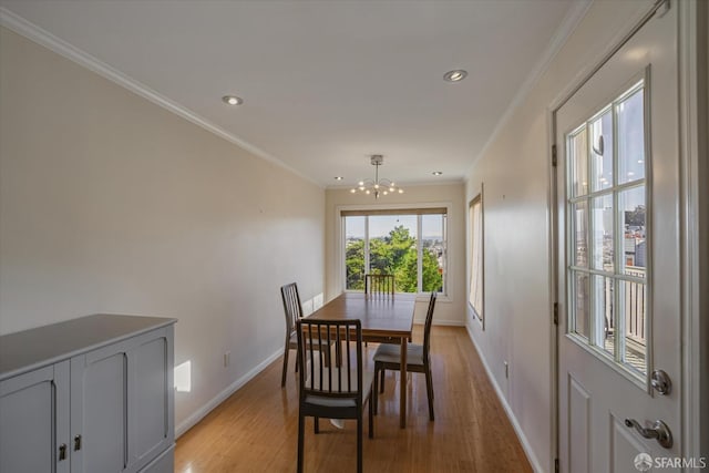 dining room featuring light hardwood / wood-style flooring, ornamental molding, and an inviting chandelier