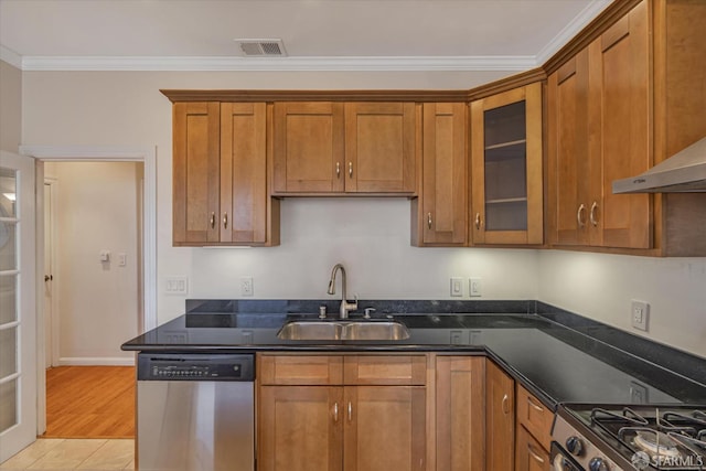 kitchen featuring sink, light hardwood / wood-style flooring, dark stone countertops, ornamental molding, and stainless steel appliances