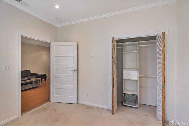 carpeted bedroom featuring crown molding and a closet