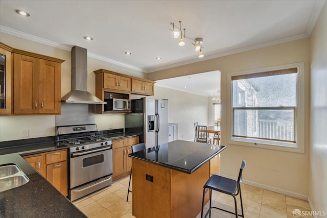 kitchen with stainless steel appliances, wall chimney range hood, a kitchen island, a kitchen breakfast bar, and light tile patterned flooring