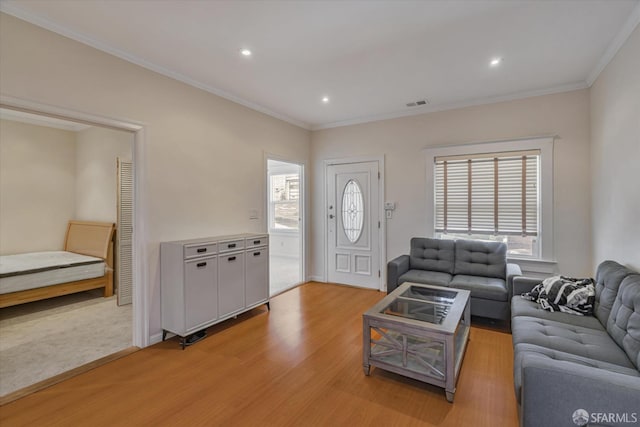 living room with light wood-type flooring and crown molding