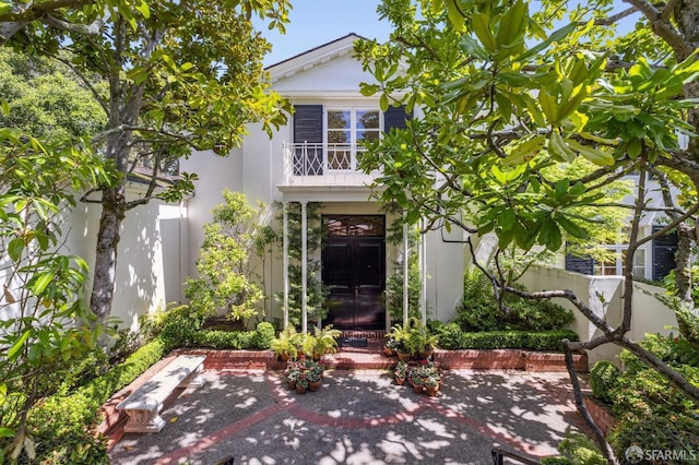 view of front facade featuring fence, a patio, and stucco siding