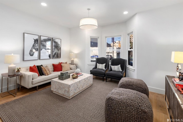 living room featuring baseboards, light wood-style flooring, and recessed lighting