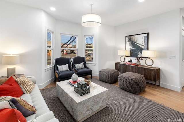 living area featuring baseboards, wood finished floors, and recessed lighting