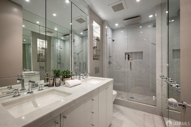 bathroom with vanity, toilet, and a shower with door