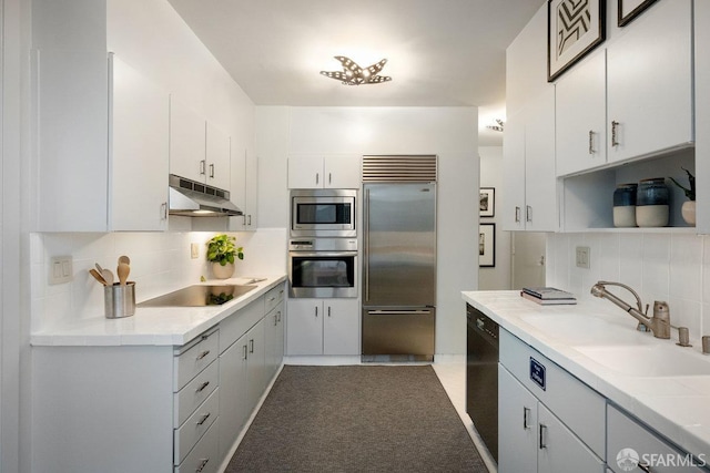 kitchen with sink, backsplash, white cabinetry, and black appliances