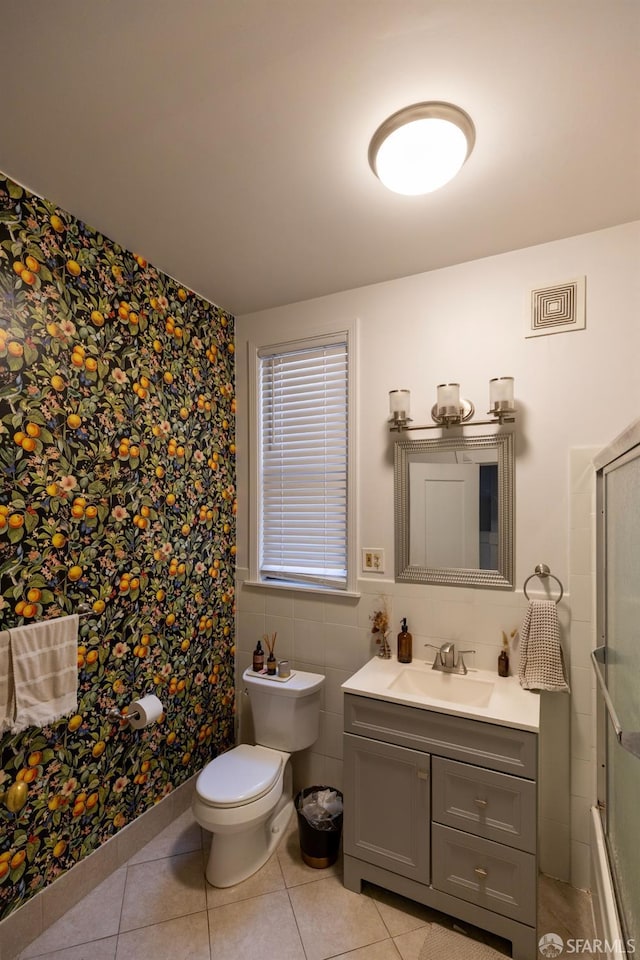 full bathroom featuring vanity, tile patterned flooring, toilet, and tile walls