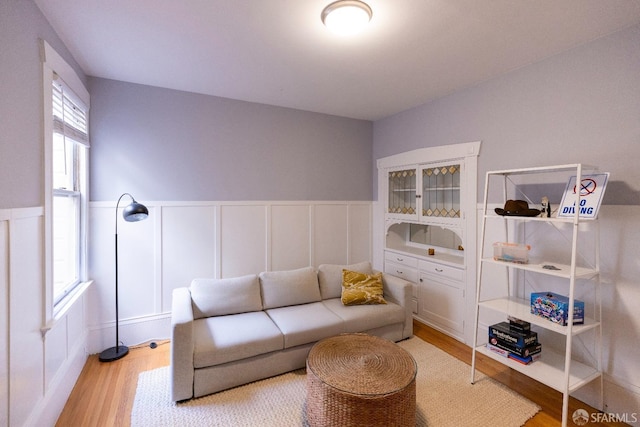 living room featuring light wood-type flooring and wainscoting