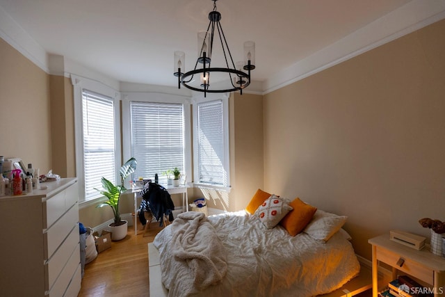 bedroom featuring a chandelier, light wood finished floors, crown molding, and baseboards