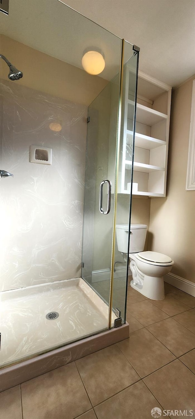 full bath with a shower stall, tile patterned floors, baseboards, and toilet