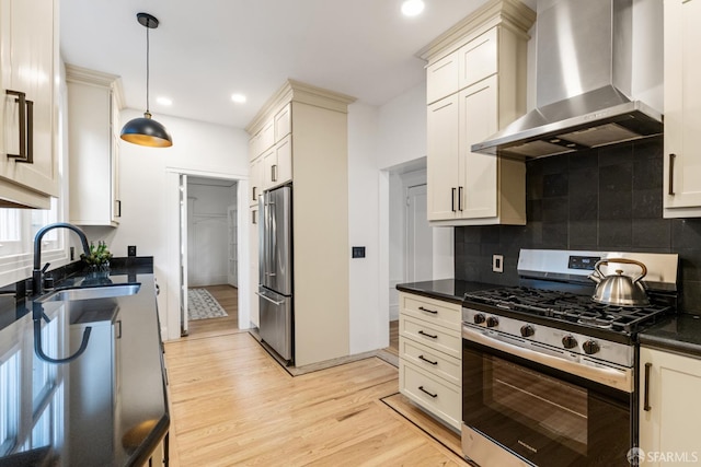 276 Funston Ave, San Francisco, CA 94118 - kitchen with appliances with stainless steel finishes, wall chimney exhaust hood, a sink, light wood finished floors, and decorative light fixtures