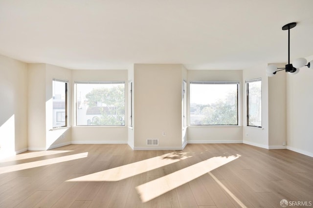 unfurnished room featuring a healthy amount of sunlight and light wood-type flooring