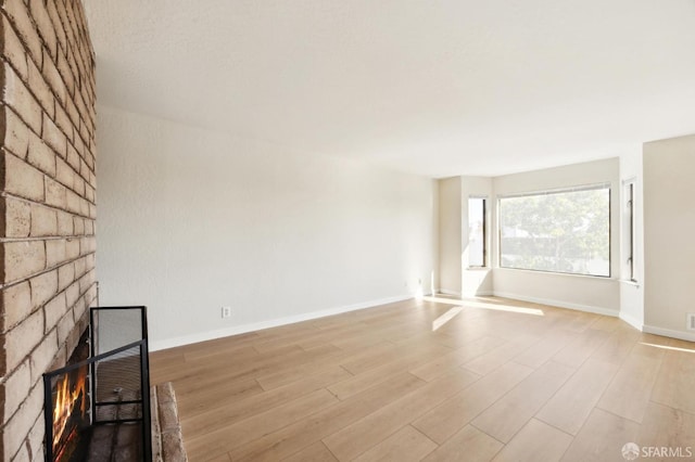 unfurnished living room with a fireplace and light wood-type flooring