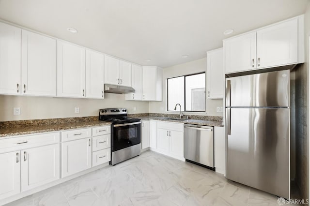 kitchen featuring sink, stainless steel appliances, dark stone counters, and white cabinets