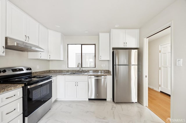 kitchen with white cabinetry, appliances with stainless steel finishes, sink, and dark stone counters