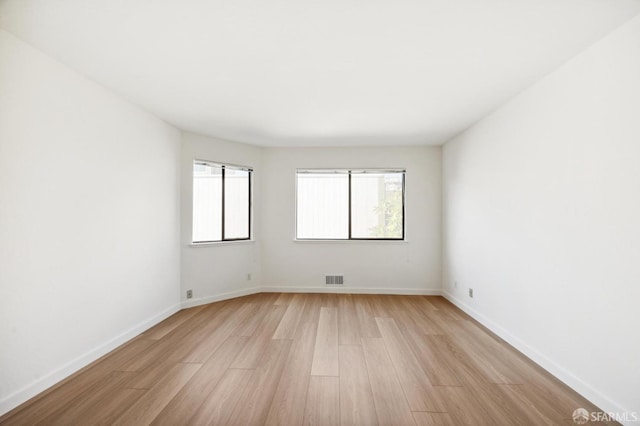 empty room with light hardwood / wood-style flooring and a wealth of natural light