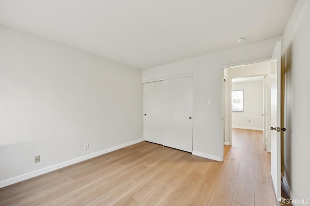 unfurnished bedroom featuring a closet and light hardwood / wood-style flooring