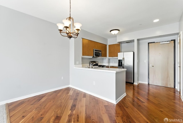5800 3rd St Unit 1401, San Francisco, CA 94124 - kitchen with stainless steel appliances, brown cabinets, light countertops, a peninsula, and dark wood-type flooring