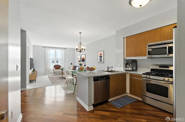 5800 3rd St Unit 1401, San Francisco, CA 94124 - kitchen featuring appliances with stainless steel finishes, a peninsula, light countertops, a chandelier, and dark wood finished floors