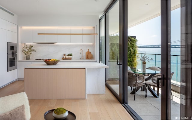 kitchen featuring modern cabinets, light countertops, and a sink