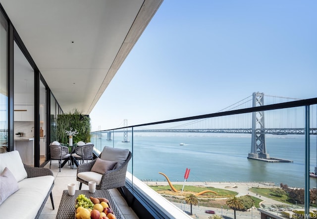 balcony featuring an outdoor living space and a water view