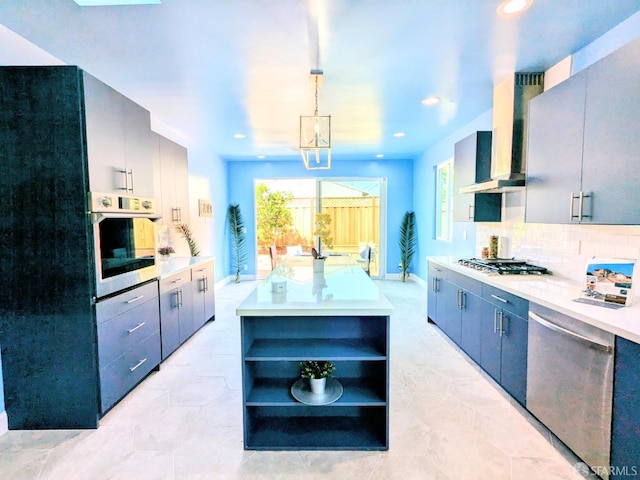 kitchen with ventilation hood, hanging light fixtures, decorative backsplash, appliances with stainless steel finishes, and a kitchen island