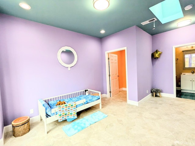 bedroom with connected bathroom and a skylight