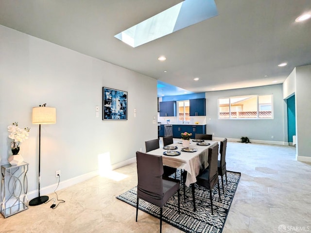 dining room featuring baseboards, recessed lighting, and a skylight