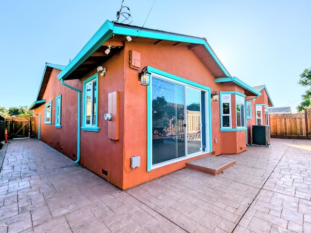 back of property with a patio area and central AC