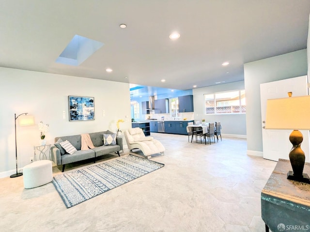 living room featuring recessed lighting, baseboards, and a skylight