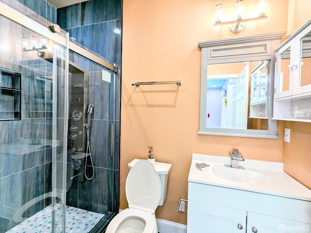 bathroom featuring toilet, vanity, and a shower stall