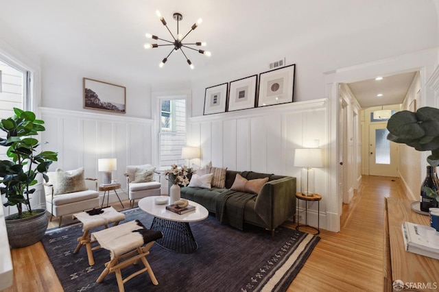 living room with light wood-type flooring and a notable chandelier