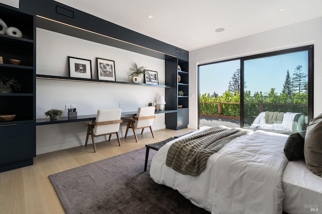 bedroom with light wood-style floors, access to outside, and built in study area