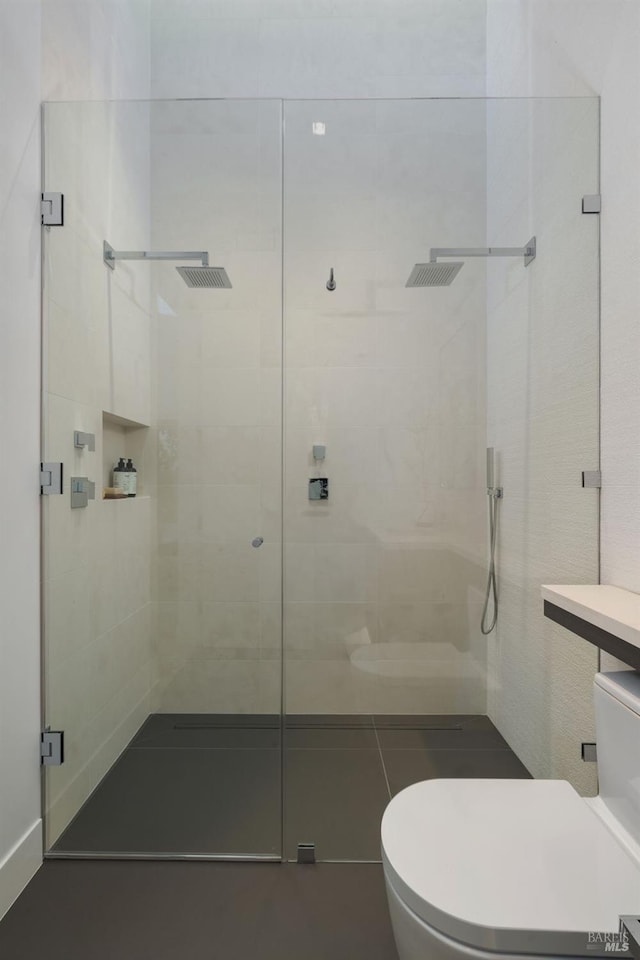 bathroom featuring toilet and a shower stall