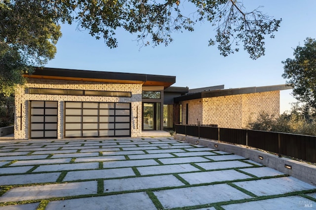 view of front of property featuring an attached garage and fence