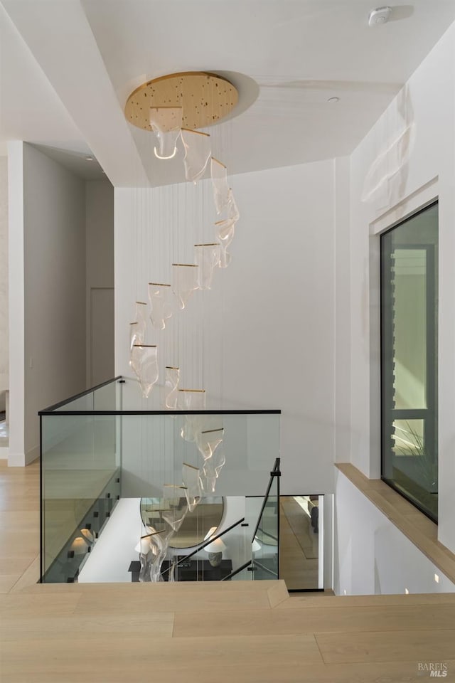hall featuring wood finished floors and an upstairs landing