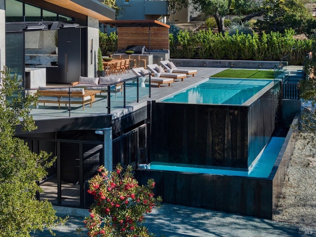 view of swimming pool with a grill, a swimming pool, and outdoor dry bar