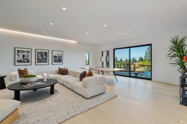 living room with light wood-type flooring and recessed lighting