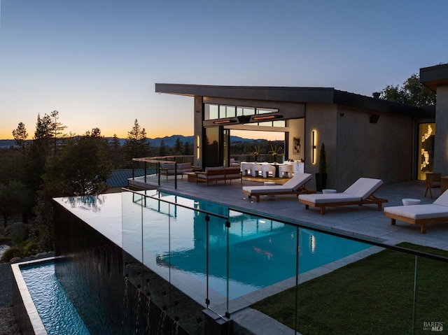 view of pool featuring an infinity pool, a patio area, and outdoor lounge area