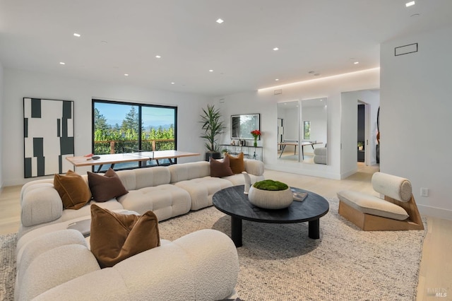 living room featuring baseboards, recessed lighting, and light wood-style floors