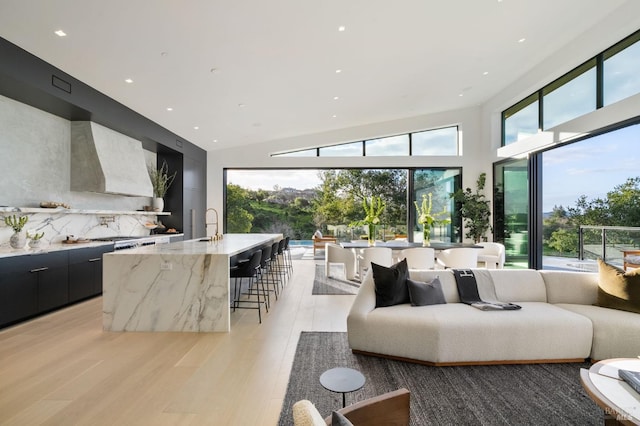 living room with light wood-type flooring and recessed lighting