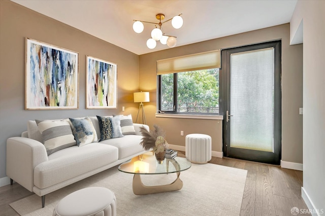 living room featuring light wood-type flooring and a chandelier