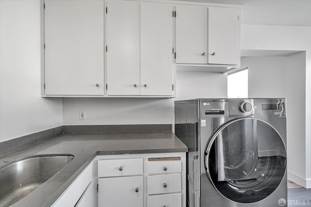 laundry room with cabinet space, washer / clothes dryer, and a sink