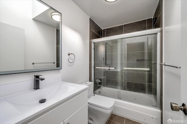 bathroom featuring shower / bath combination with glass door, vanity, toilet, and tile patterned floors