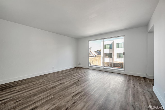 unfurnished room with dark wood-style floors and baseboards