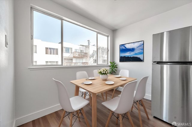 dining area with baseboards and wood finished floors