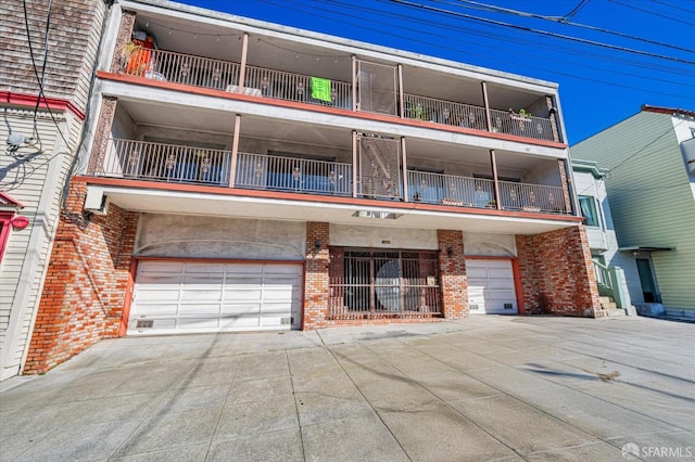 multi unit property featuring driveway, brick siding, and an attached garage