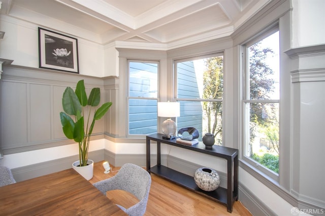 home office with coffered ceiling, healthy amount of natural light, crown molding, beam ceiling, and a decorative wall