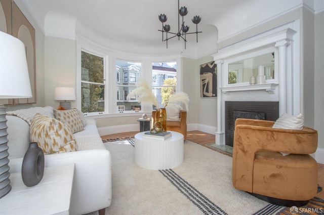 living area with a chandelier, a fireplace with flush hearth, and baseboards