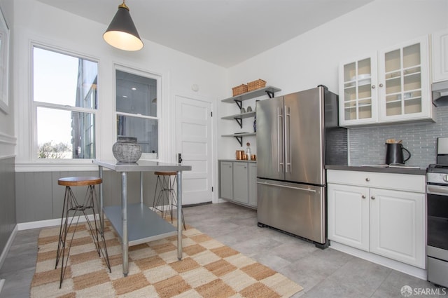 kitchen featuring stainless steel appliances, white cabinets, tasteful backsplash, open shelves, and glass insert cabinets